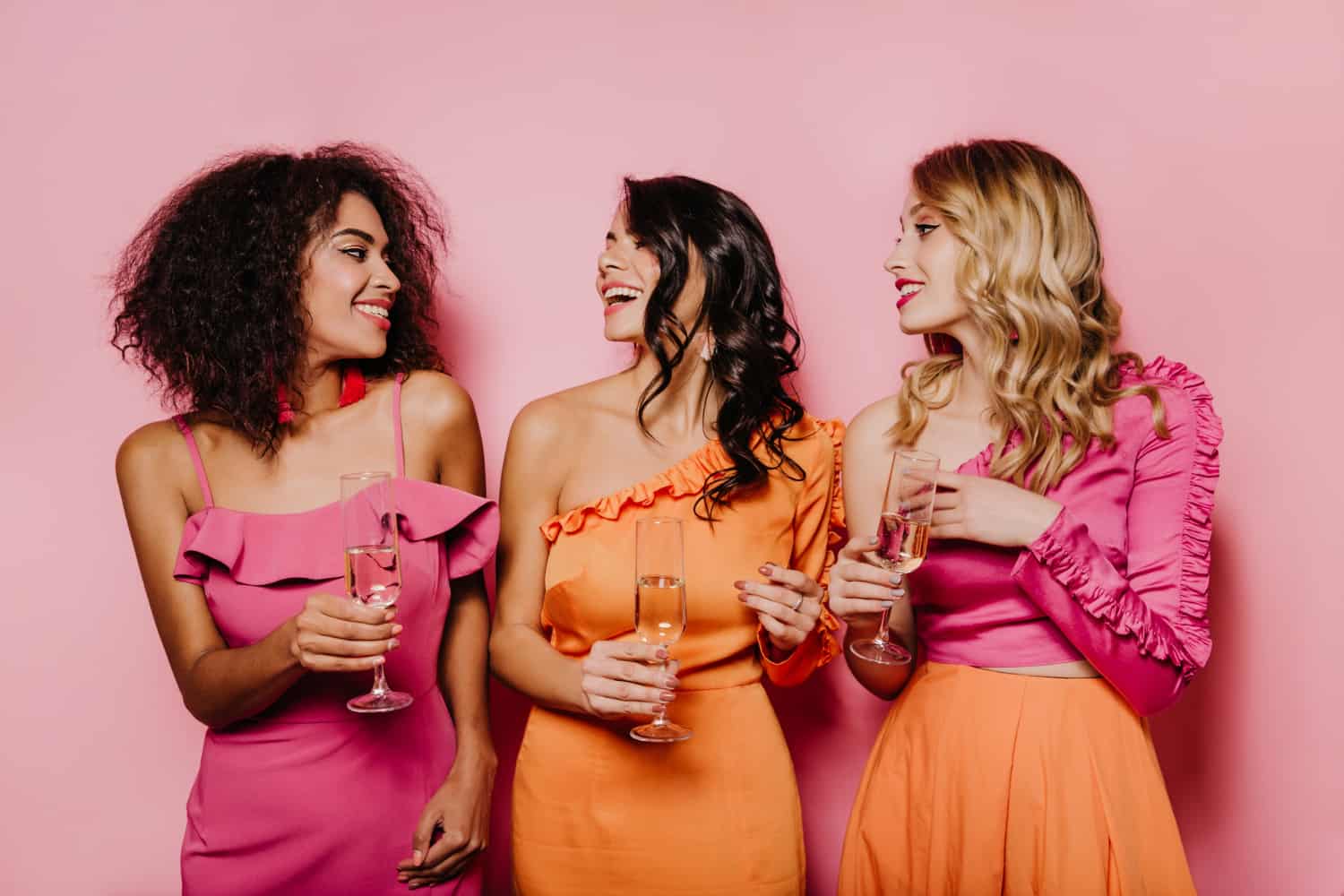 2-tinute cocktail- 3 femei in rochii asortate roz si portocaliu, fundal roz(3)